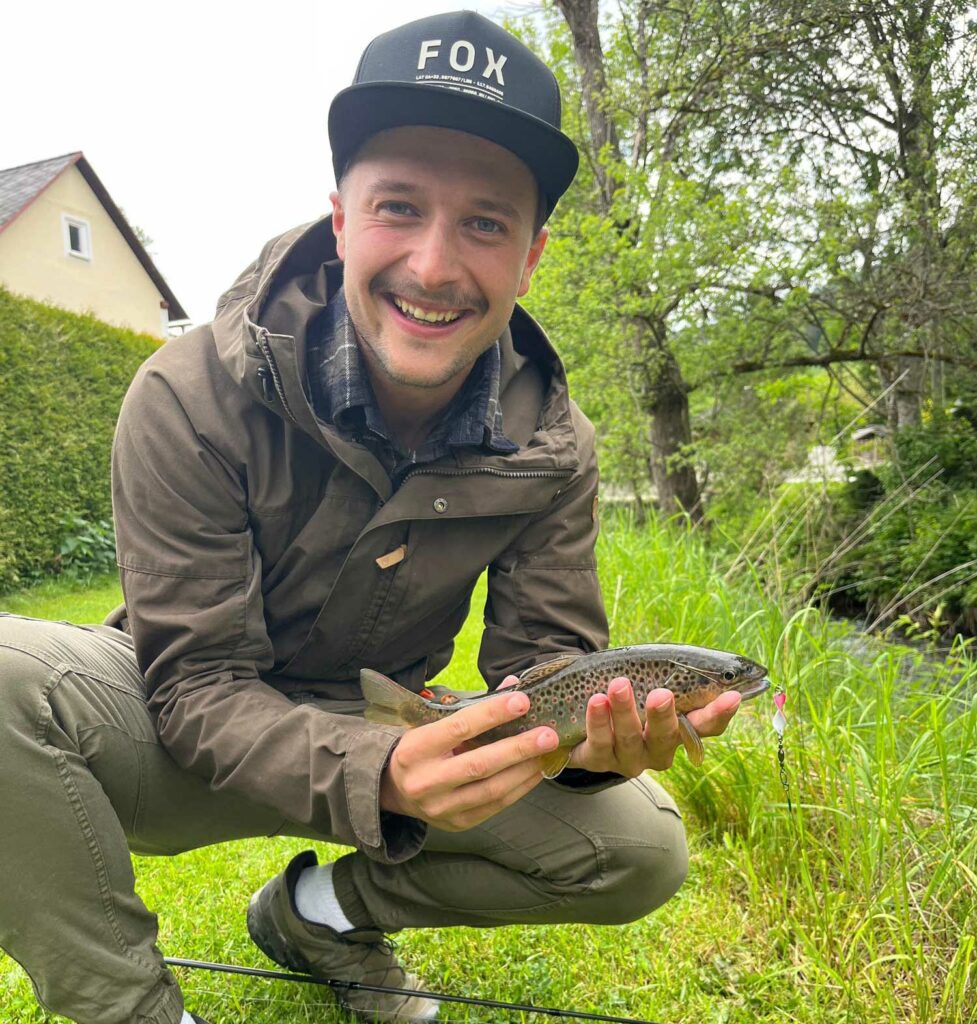 Niki Löcker vom Hemmadorf in Glödnitz hält einen selbst geangelten Fisch in der Hand.